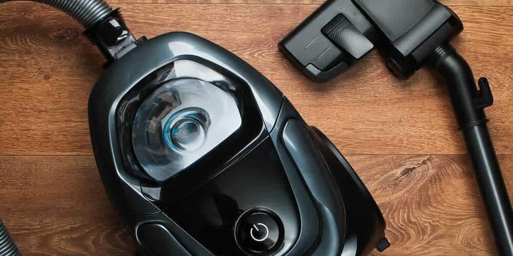 Vacuum cleaner on wooden floor. Top view. Cleaning concept. Vacuum cleaner on wooden floor. Top view. Cleaning concept.