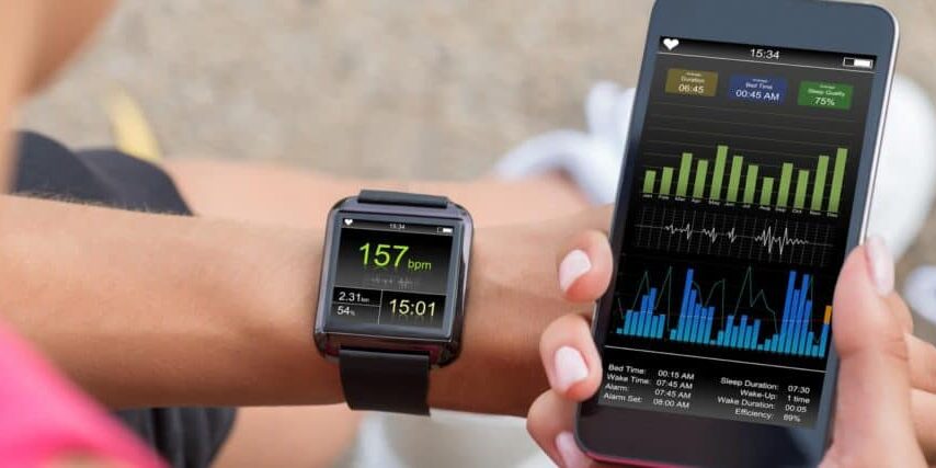 Female Runner Looking At Her Mobile And Smart Watch Heart Rate Monitor